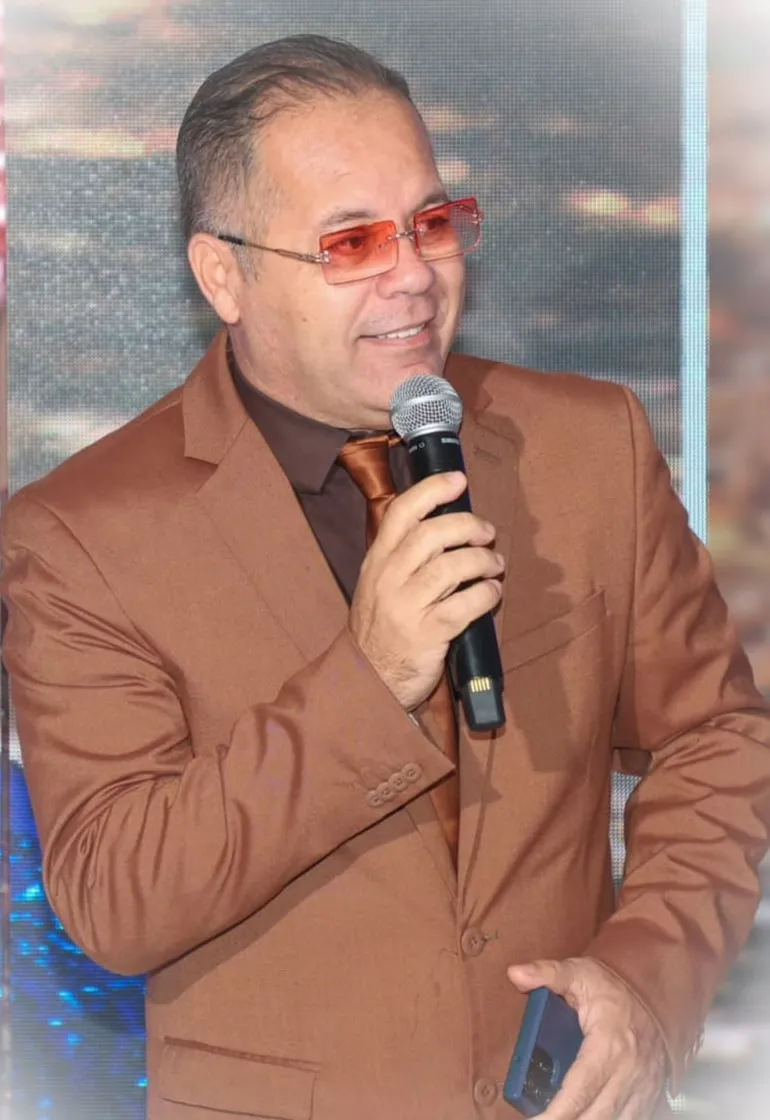 Miguel Eduardo conduciendo un evento, micrófono en mano